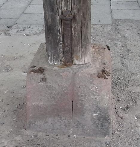 Holzstütze auf Naturstein
Die Holzstütze für das Dach einer Lagerhalle steht direkt auf dem Naturstein. Durch die Höhe des Steines ist die Stütze ausreichend vom feuchten Boden entfernt.