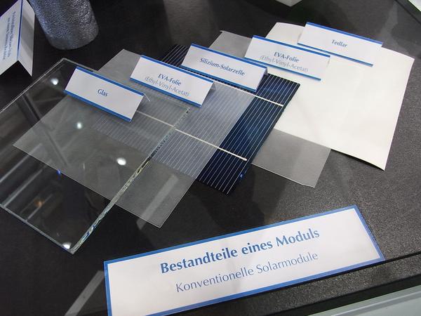 Solarmodul in Einzelteilen
In der Vitrine liegen die Einzelteile eines Solarmoduls. Oberste Schicht ist ein Glas. Solarglas ist sehr widerstandsfähig. Es muss Regen, Schnee und Hagel, wechselnde Temperaturen