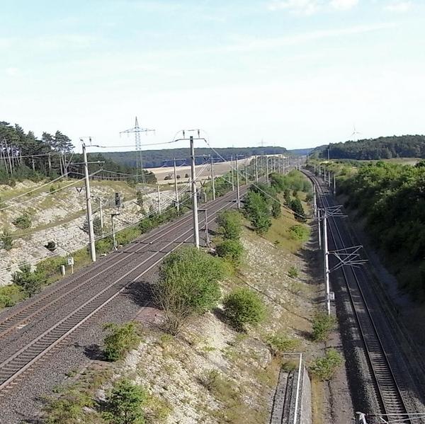 Bahntrasse - Einschnitt in die Natur
Diese Bahntrasse bildet einen gewaltigen Einschnitt in die Natur. Wie eine gut bewachte Grenze teilt sie das Land. An den Stromleitungen kann man sehen, das es sich