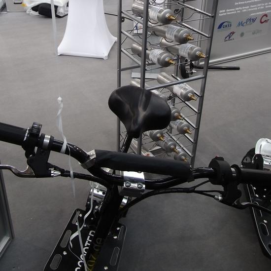 Brennstoffzelle im Roller
Im Regal hinter dem Roller liegen die Druckflaschen. Solche Flaschen mit Wasserstoff sollen später einmal die kleinen Roller antreiben. Ob das gut geht?