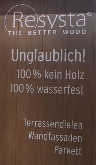 Holz-Ersatz
Das Werbeschild für ein neues Produkt sagt als erstes, was es nicht ist. 100 % kein Holz ist eine Botschaft, von der man noch nicht weiß, was sie bedeutet.