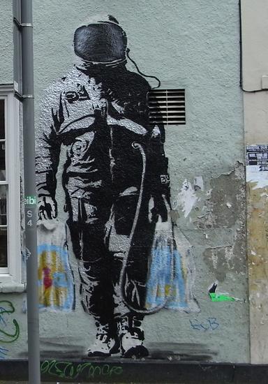 Astronaut mit Lidl-Tüten
Der Astronaut oder auch Kosmonaut, je nachdem aus welcher Richtung man ihn betrachtet, ist auch eines der Werke von Banksy.