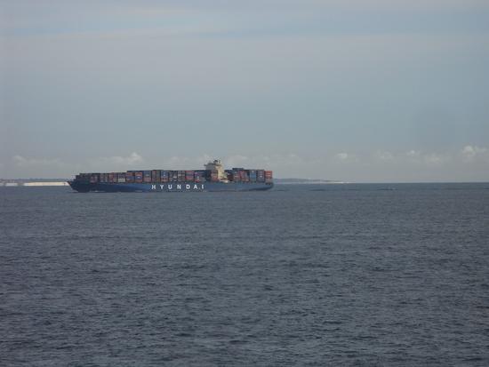 Ein Frachtschiff kreuzt unseren Weg
Die englische Küste ist schon in Sicht, als ein Frachter unseren Weg zu kreuzen scheint. Hunderte von Containern hat er geladen.