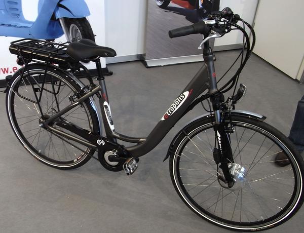 Cityrad mit Elektroantrieb
Am Stand von e-tropolis steht ein sogenanntes Citybike. Gekennzeichnet durch einen tiefen Einstieg, ordentliche Schutzbleche über den Rädern und vorschriftsmäßiger Beleuchtung.