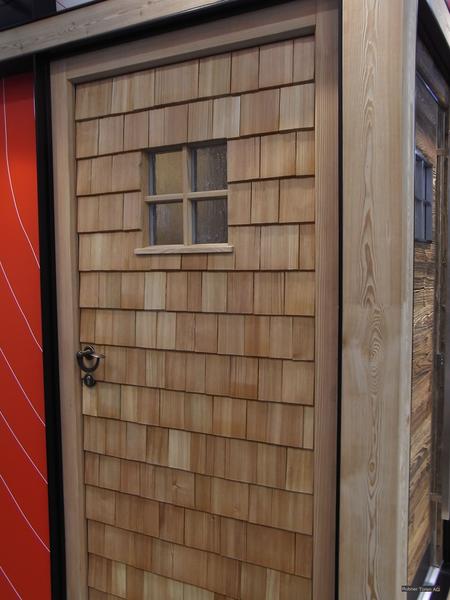 Schindel-Haustür
Hier wird eine Haustür mit einem Schindelbelag gezeigt. Für ein Haus, dessen Fassade mit Holzschindeln belegt ist, sollte das unbedingt die richtige Wahl sein.
