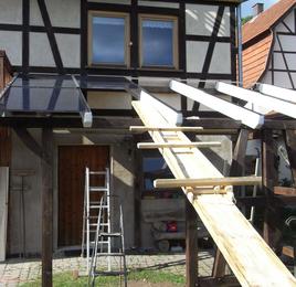 Glas-Glas-Module werden montiert
Für die Montage der Glas-Glas-Module habe ich mir eine einfache Hilfsvorrichtung gebaut. Auf einer Gerüstbohle sitzt ein Schlitten, auf dem je ein Modul nach oben geschoben wird.
Bild 1