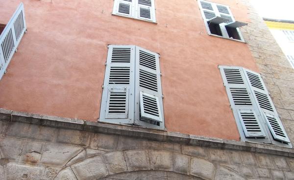 Stadthaus mit Fensterläden
An dieser Fassade erkennt man 3 wesentliche Merkmale des regionalen Baustils. Naturstein, Naturfarben im Putz und die traditionellen Holzfensterläden mit ihren vielen Funktionen.